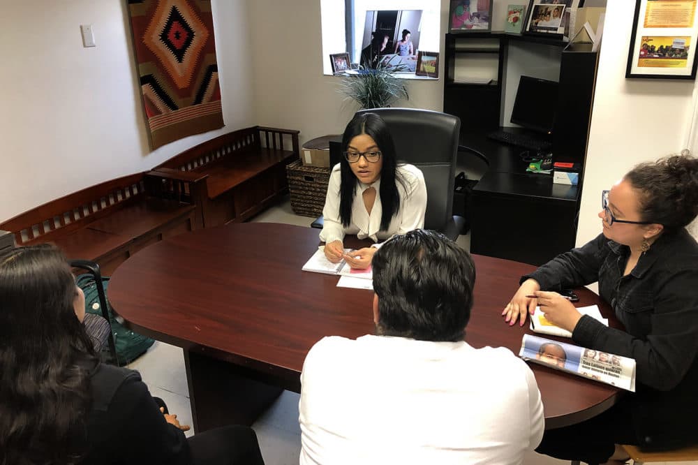 Patricia Montes, center facing forward, of Centro Presente, meets with the parents of children in immigration detention. (Shannon Dooling/WBUR)