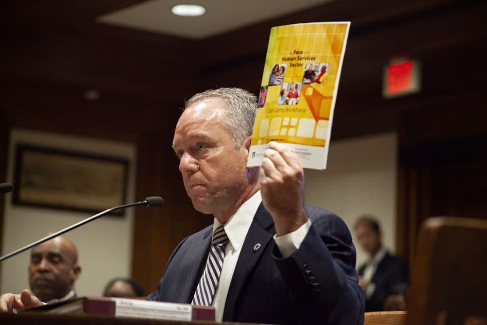 Rep. Jeff Roy held up a report on challenges faced by the human services industry while speaking Tuesday in support of his bill to create a student-loan repayment program for human services workers. (Chris Lisinski/SHNS)
