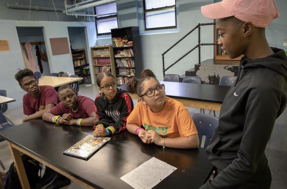 Teacher Taliana Jeune talks with seventh graders at Helen Y. Davis Leadership Academy Charter Public School. (Robin Lubbock/WBUR)