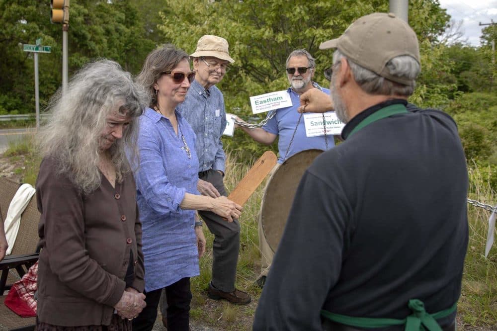 Diane Turco, director of Cape Downwinders, rings a gong to mark the day the Pilgrim nuclear plant ceased power production. (Robin Lubbock/WBUR)