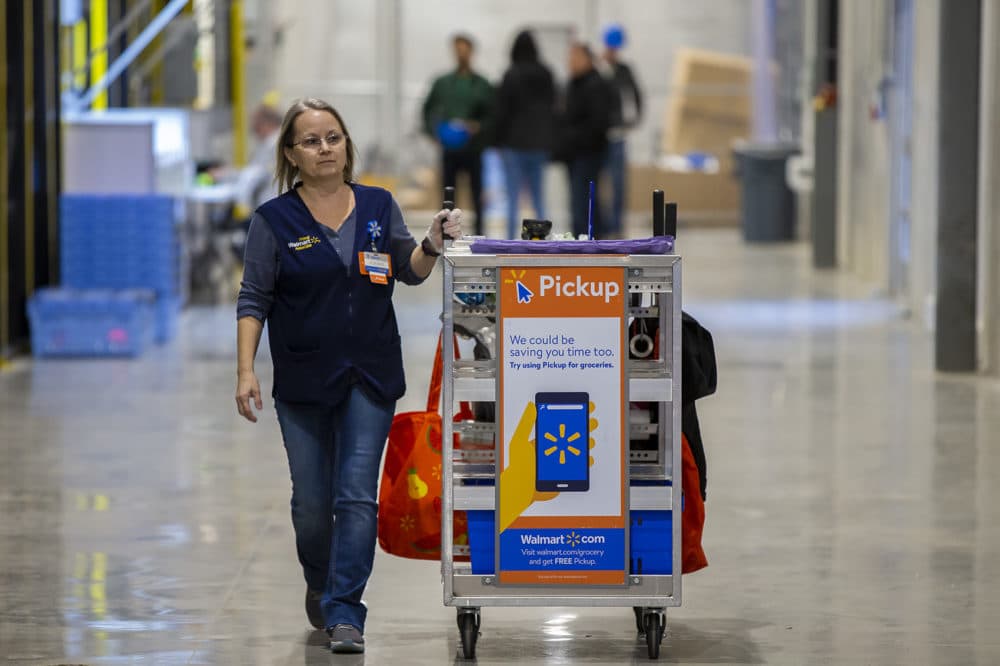 A Walmart associate rolls a cart full down the hallway of the warehouse in Salem, New Hampshire. (Jesse Costa/WBUR)