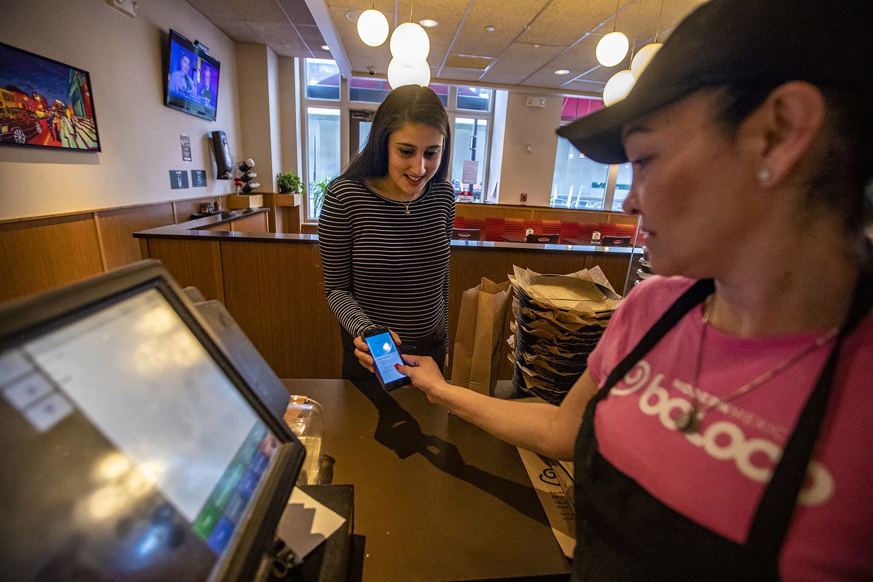 Swathi Joshi purchases a breakfast burrito with the “Food For All” app at Boloco at Atlantic Wharf. (Jesse Costa/WBUR)
