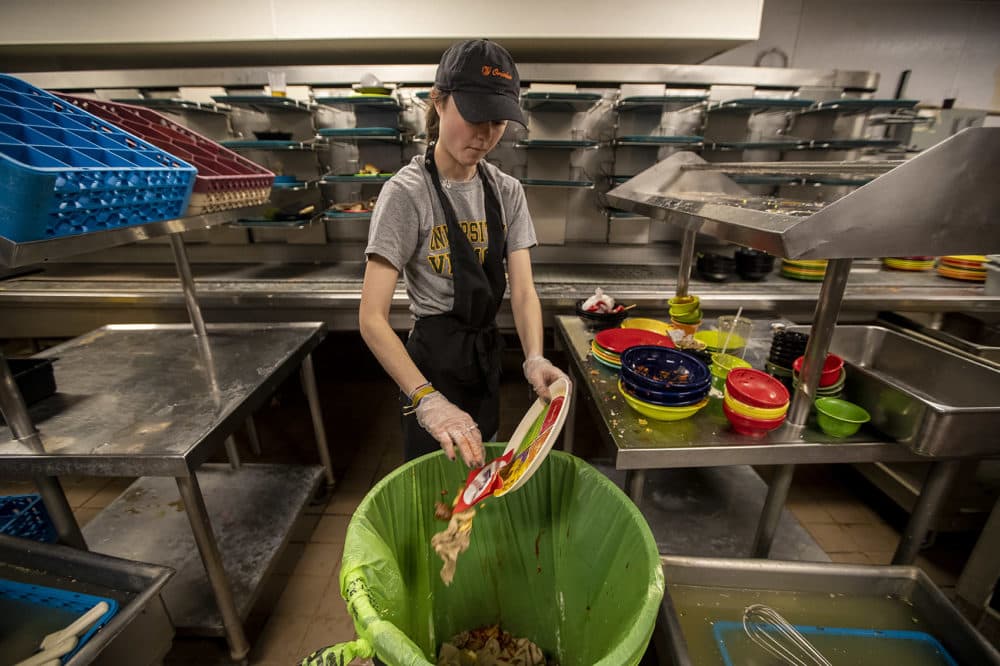 Sarah Anastasio cleans off a plate in the dining hall in Kimball Hall at the College of the Holy Cross. (Jesse Costa/WBUR)