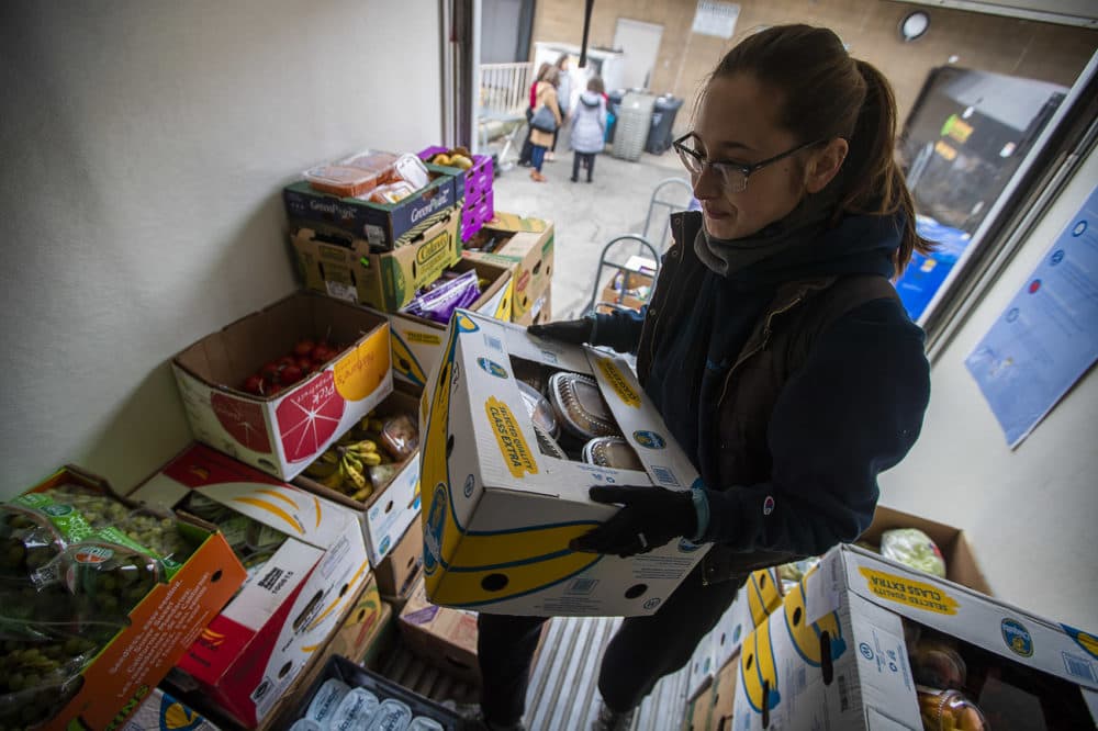 Lovin' Spoonfuls food rescue coordinator Yenny Martin loads produce into the organization's truck before delivering it to shelters and addiction treatment centers. (Jesse Costa/WBUR)