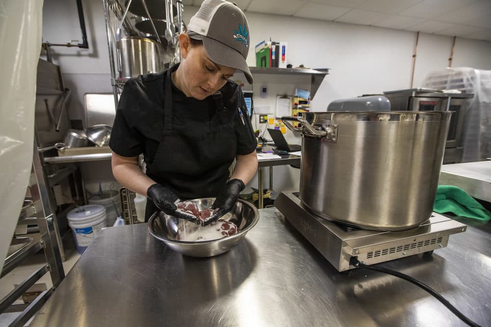 Sira Naturals chef and infusions manager Annie Wolf covers Mixed Berry Fruit Jewels in sugar prior to packaging. (Jesse Costa/WBUR)