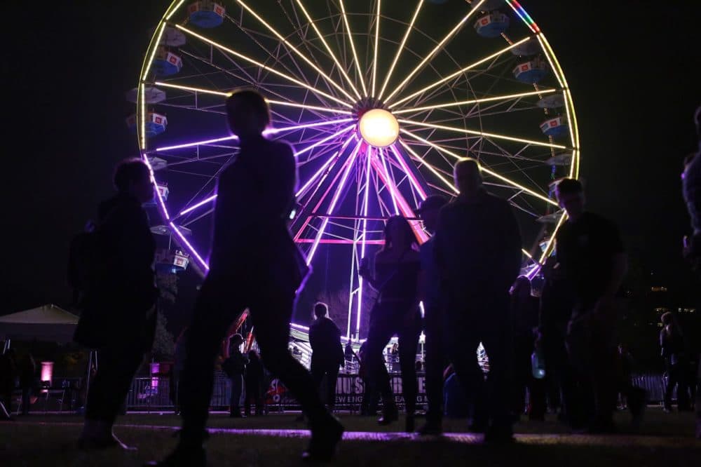 People walk past the Ferris wheel on Friday night at Boston Calling. (Hadley Green for WBUR)