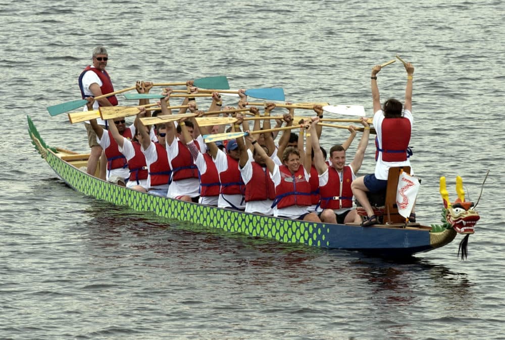 The drummer, right, at the bow of the boat leads a crew in some pre-race stretching before the start of competition at the Dragon Boat Festival on the Charles River in Cambridge in 2002. (Robert E. Klein/AP)