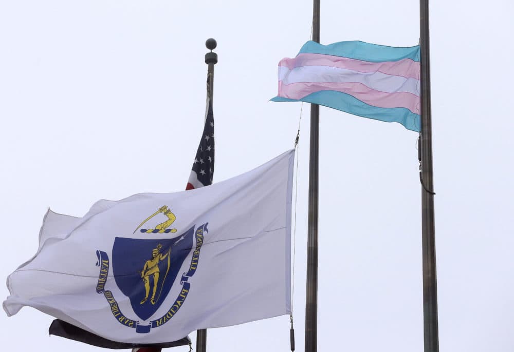 In this 2016 file photo, a flag representing the transgender community, foreground, flies next to the Massachusetts state flag and a U.S. flag in front of Boston City Hall. (Steven Senne/AP)