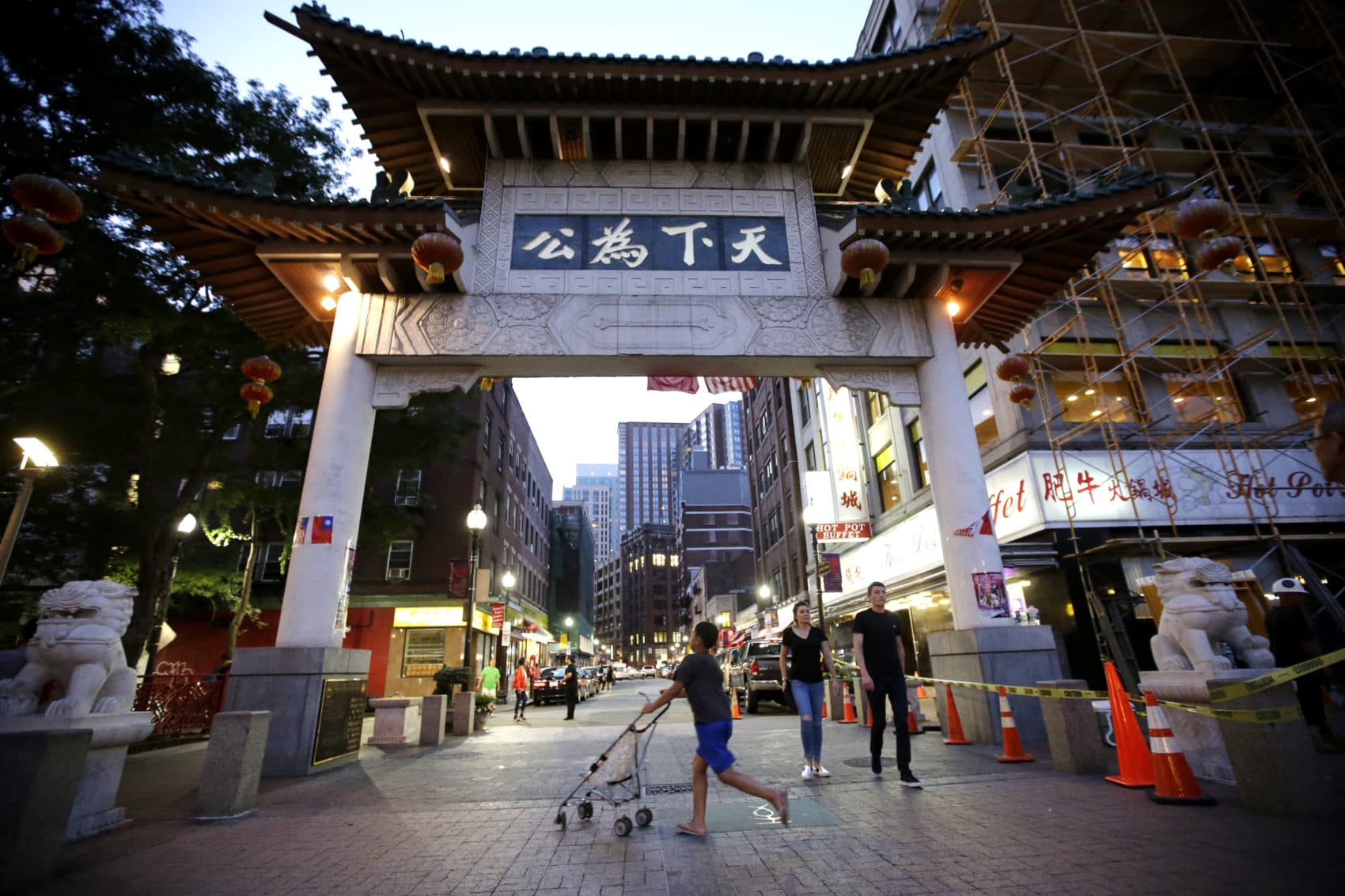 A child pushes a stroller under a gate to Boston's Chinatown neighborhood. (Steven Senne/AP)