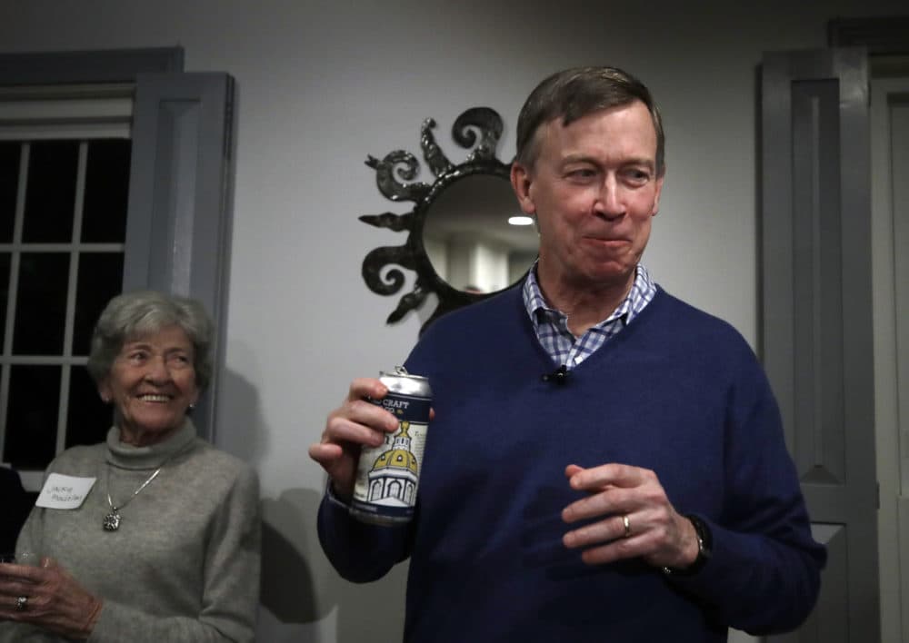 Former Colorado Gov. John Hickenlooper smiles after sipping a New Hampshire craft beer called The Gov'nah at a campaign house party on Feb. 13, 2019, in Manchester. (Elise Amendola/AP)