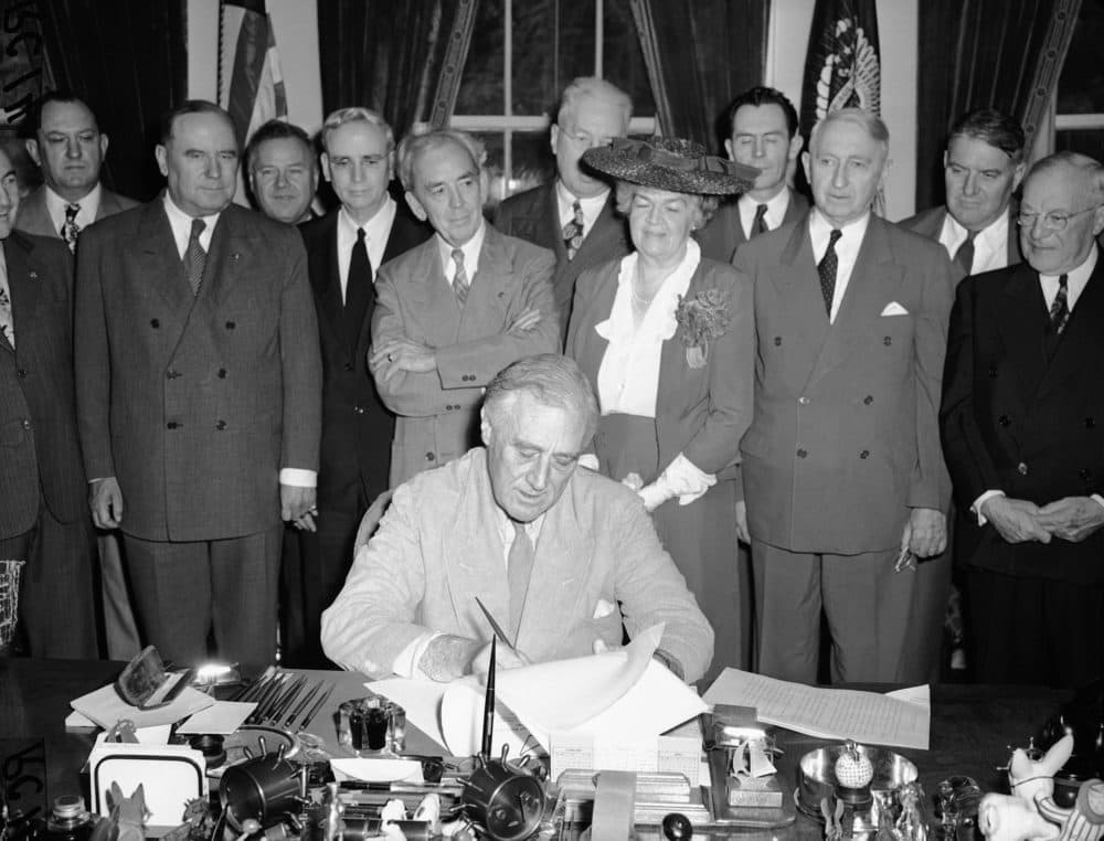 President Franklin Delano Roosevelt puts his signature on the G.I. Bill of Rights at the White House on June 22, 1944. Rogers is among those gathered. (Robert Clover/AP)