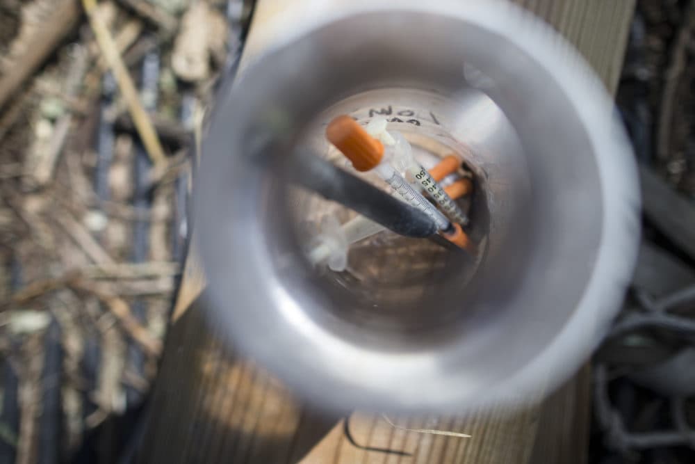 In this Thursday, Sept. 17, 2015, photo, used heroin syringes are stored in a water bottle as Steve Monnin cleans a wooded area in Combs Park, in Hamilton, Ohio. (John Minchillo/AP)