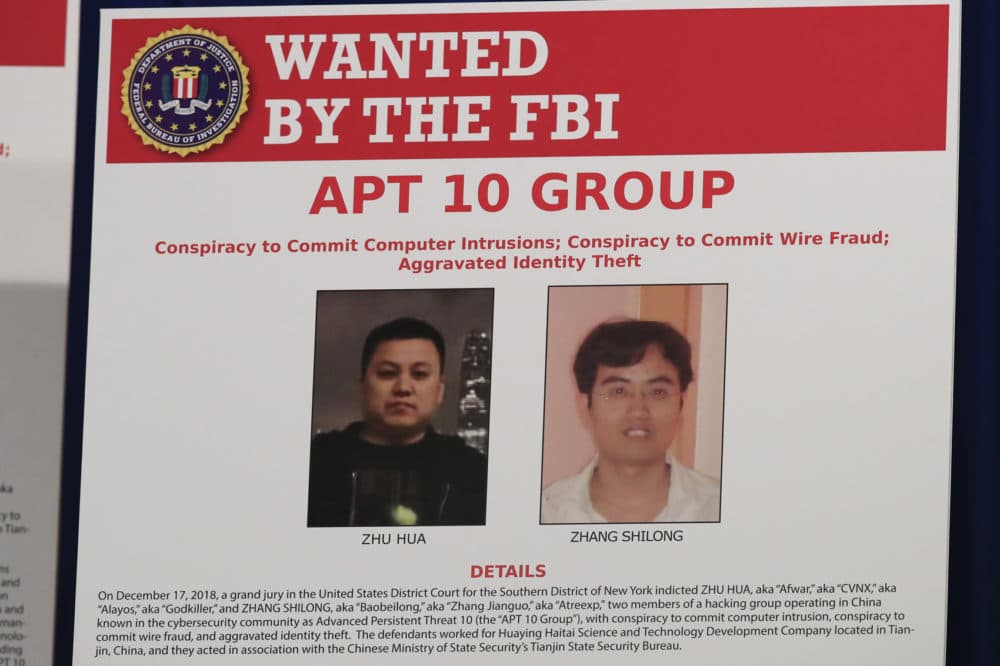 A poster displayed during a news conference at the Department of Justice in Washington, Thursday, Dec. 20, 2018, shows two Chinese citizens suspected to be with the group APT 10 carrying out an extensive hacking campaign to steal data from U.S. companies. (Manuel Balce Ceneta/AP)