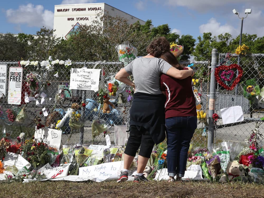 Two women look on at the memorial in front of Marjory Stoneman Douglas High School as teachers and staff are allowed to return to the school for the first time since the mass shooting on campus on Feb. 23, 2018 in Parkland, Fla. (Joe Raedle/Getty Images)