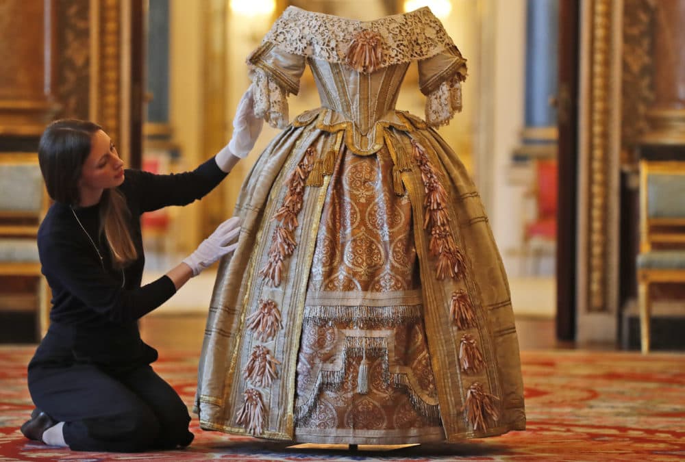 A member of the Palace staff arranges Queen Victoria's Stuart Ball costume which is part of an exhibition to mark the 200th anniversary of the birth of Queen Victoria (1819–1901) this year at Buckingham Palace in London. (Frank Augstein/AP)