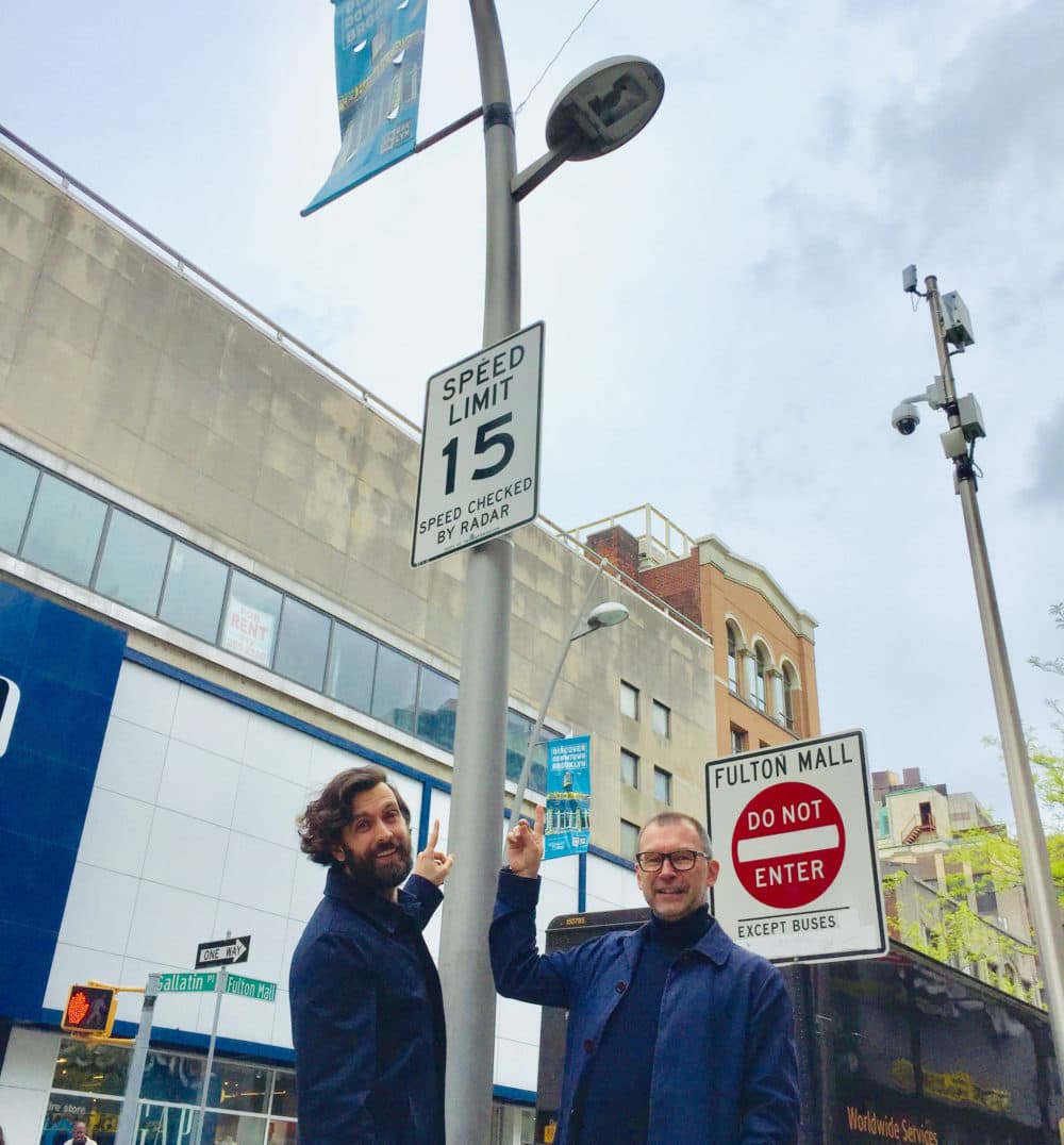 SONYC research scientist Mark Cartwright (left) and postdoctoral researcher Graham Dove point to an audio sensor in Brooklyn. (Karyn Miller-Medzon/Here &amp; Now)