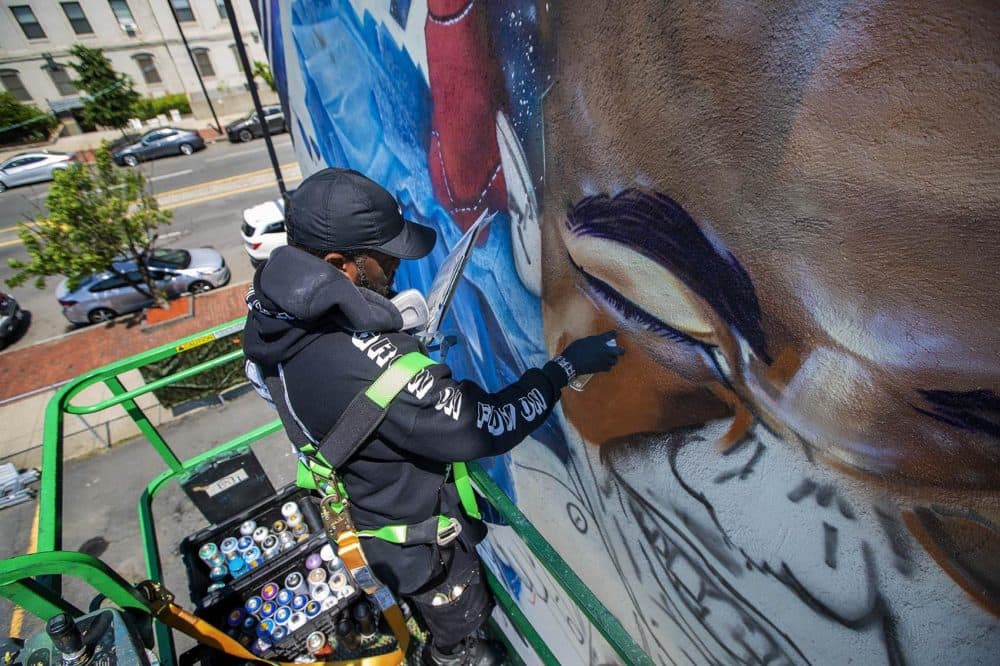 Artist Rob &quot;Problak&quot; Gibbs works on his latest mural, &quot;Breathe Life,&quot; on the side of 808 Tremont St. a three story building in Roxbury. (Jesse Costa/WBUR)