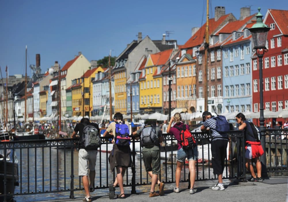 Tourists stand on a bridge and look at colorful houses in the Nyhavn district of Copenhagen, Denmark. (Johannes Eisele/AFP/Getty Images)