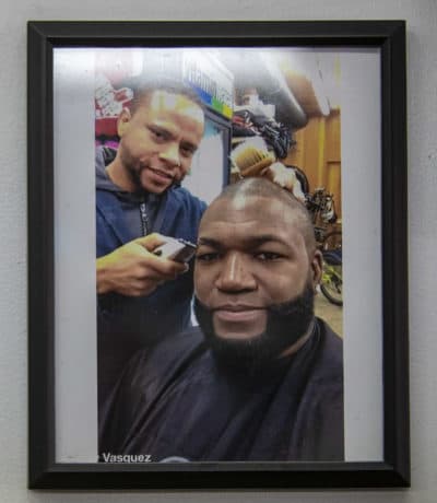 A photo on the wall shows owner José “Bacano” De La Rosa with Ortiz in his barber chair. (Jesse Costa/WBUR)