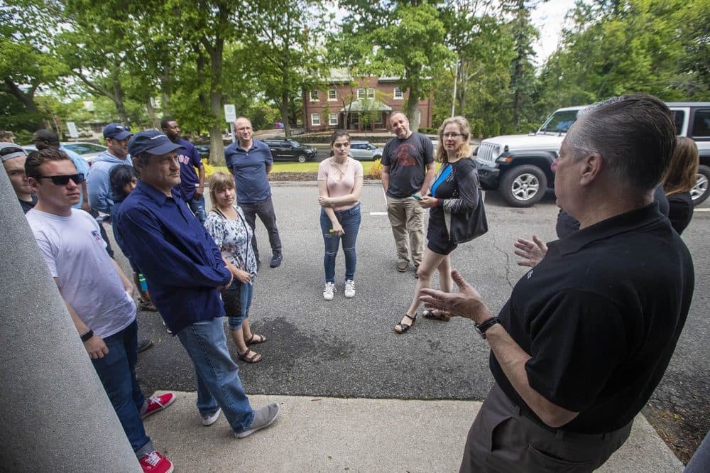 Barton Hyte, an appraisal expert helping organize tours, explains to interested buyers how the Newbury College closeout sale will be conducted. (Jesse Costa/WBUR)