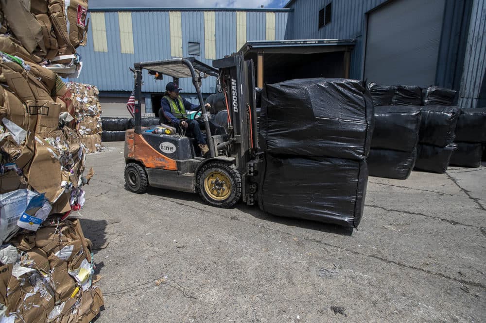 The trash is compressed into 1-ton bales, covered in plastic, and then loaded onto trucks for delivery around the country. (Jesse Costa/WBUR)