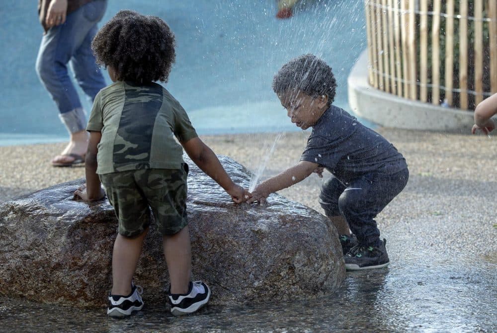 Emmitt, 19 months, and Myles, 3, play in the water fountains at Martin's Park. (Robin Lubbock/WBUR)