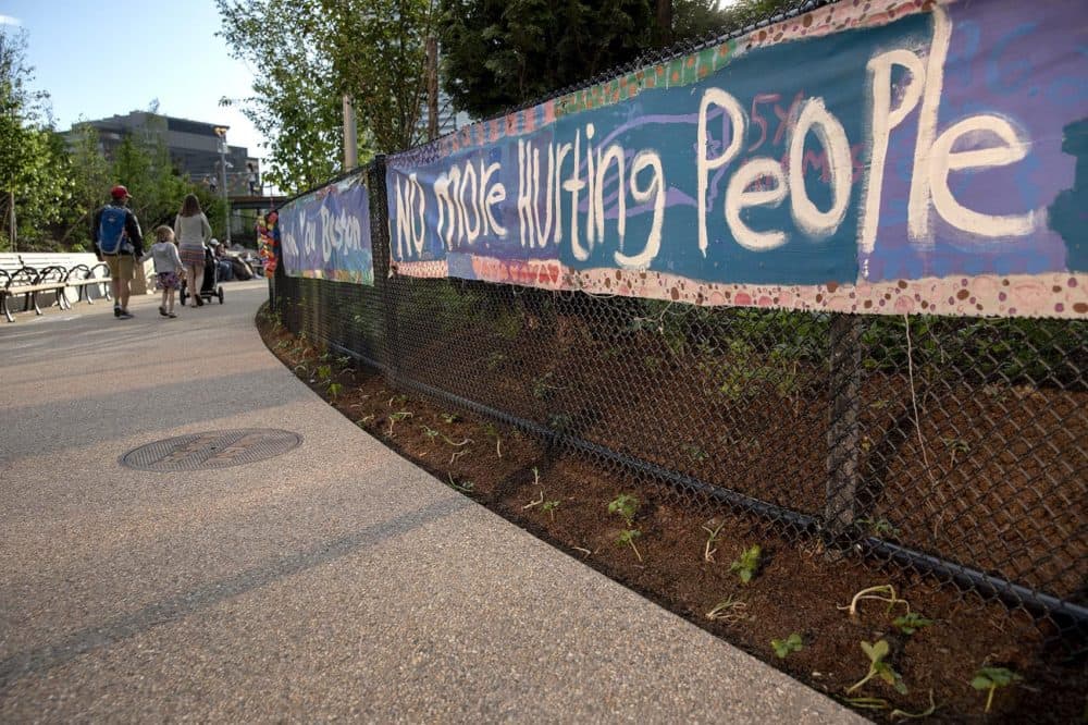 A banner hanging at the entrance of Martin's Park reads "No more hurting people." (Robin Lubbock/WBUR)