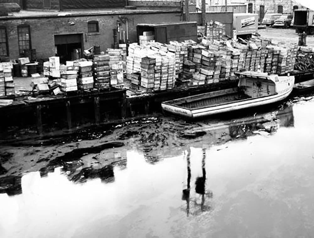 A boat sits docked next to an oily slide on the Cuyahoga River in 1961. (Courtesy of The Cleveland Press Collection)