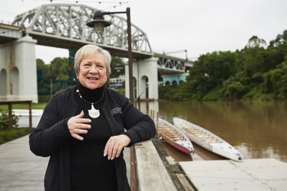Jane Goodman, executive director of Cuyahoga River Restoration, stands by the river in Cleveland. This week marks 50 years since the 13th and last recorded river fire in 1969. (Paul Sobota for Here &amp; Now)