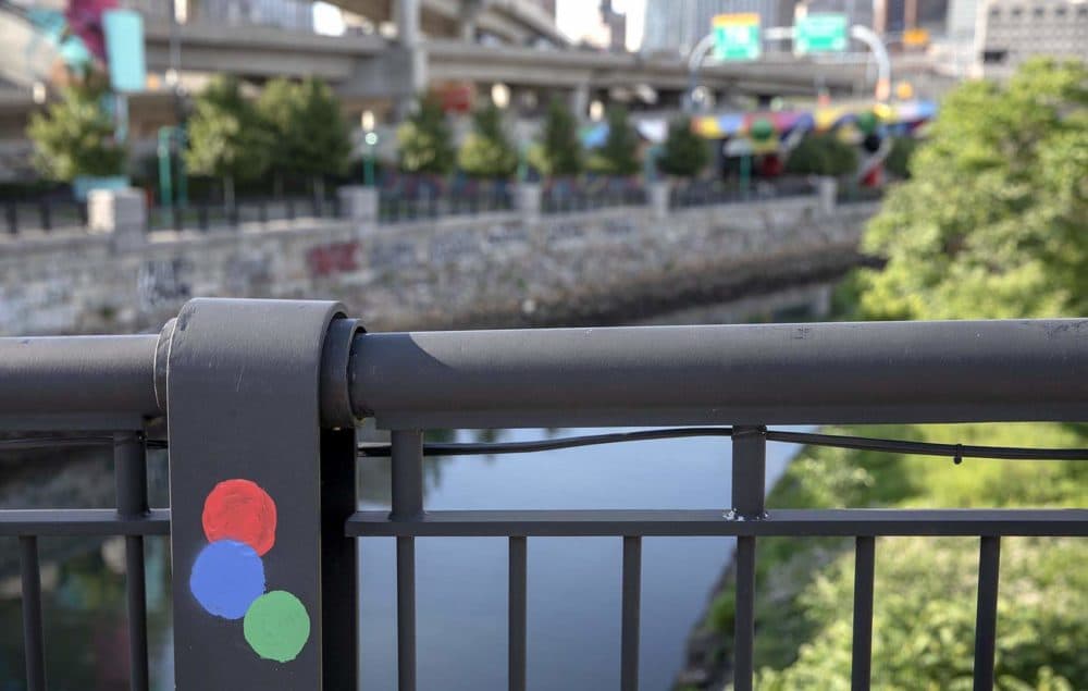 Artist Muro left three painted circles on the Traveler Street bridge at the spot where you can get a perfectly aligned view of his mural. (Robin Lubbock/WBUR)