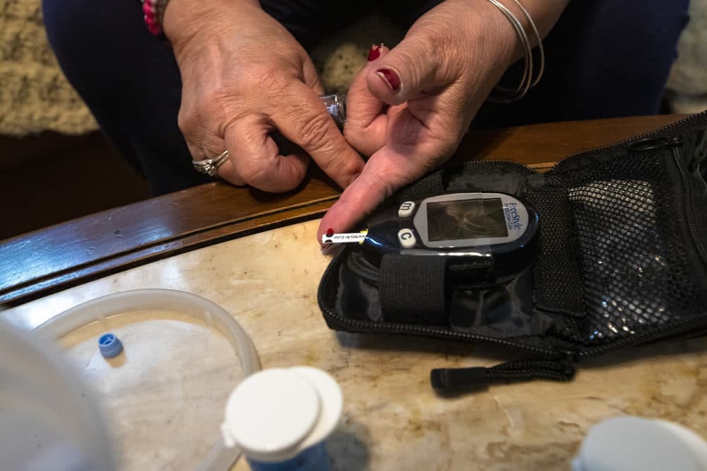 Joanne Rhoton of Everett has diabetes and here she demonstrates how she tests her blood sugar level. (Jesse Costa/WBUR)
