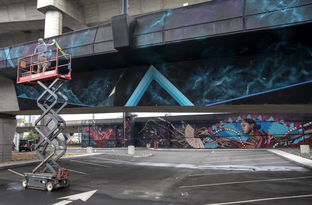 Dana Woulfe works on a mural at Underground at Ink Block. (Robin Lubbock/WBUR)