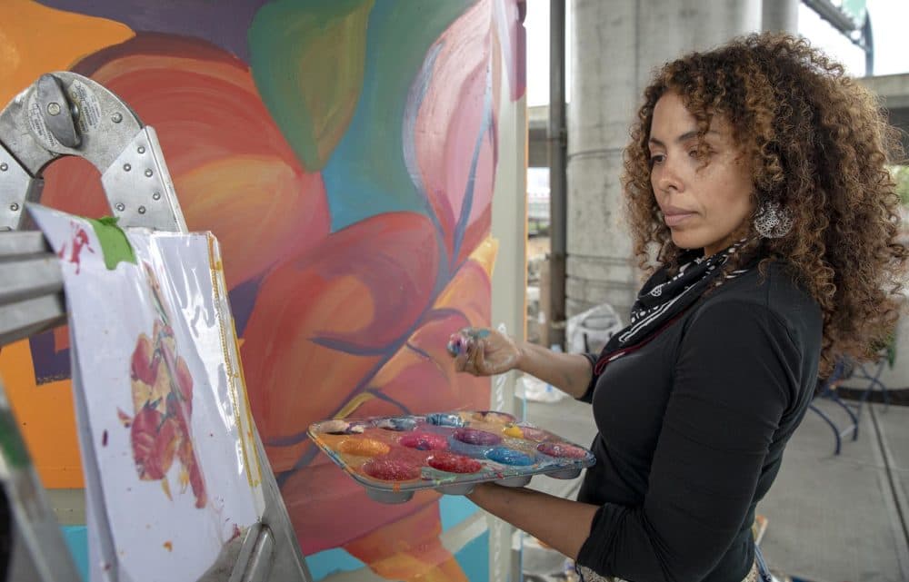 Artist Silvia López Chavez works on a pillar under I-93. (Robin Lubbock/WBUR)