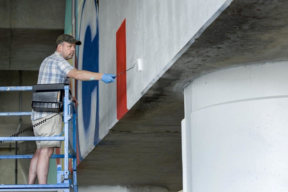 Greg Lamarche works on his mural for Underground at Ink Block. (Robin Lubbock/WBUR)