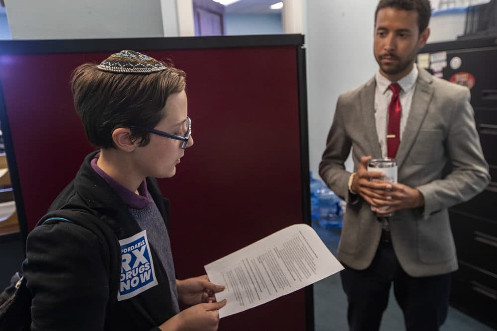 Eri Solomon, lead organizer for the Jewish Alliance for Law and Social Action, speaks with Ernesto Reyes Hernandez, legislative director in the office of Sen. Sonia Chang-Diaz, about drug prices. (Jesse Costa/WBUR)