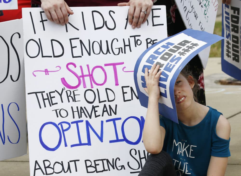 A child shields herself from the sun as people participate in a "March for Our Lives" rally in Jackson, Miss., Saturday, March 24, 2018. (Rogelio V. Solis/AP)