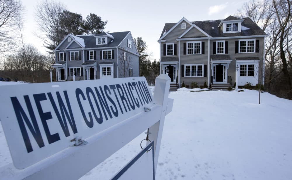 Newly constructed homes sit near a sign in Natick. (Steven Senne/AP)