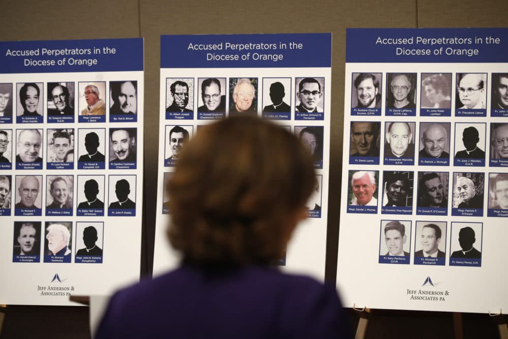 An advocate and survivor of sexual abuse looks at the photos of Catholic priests accused of sexual misconduct by victims during a news conference in Orange, Calif in 2018. (Jae C. Hong/AP)