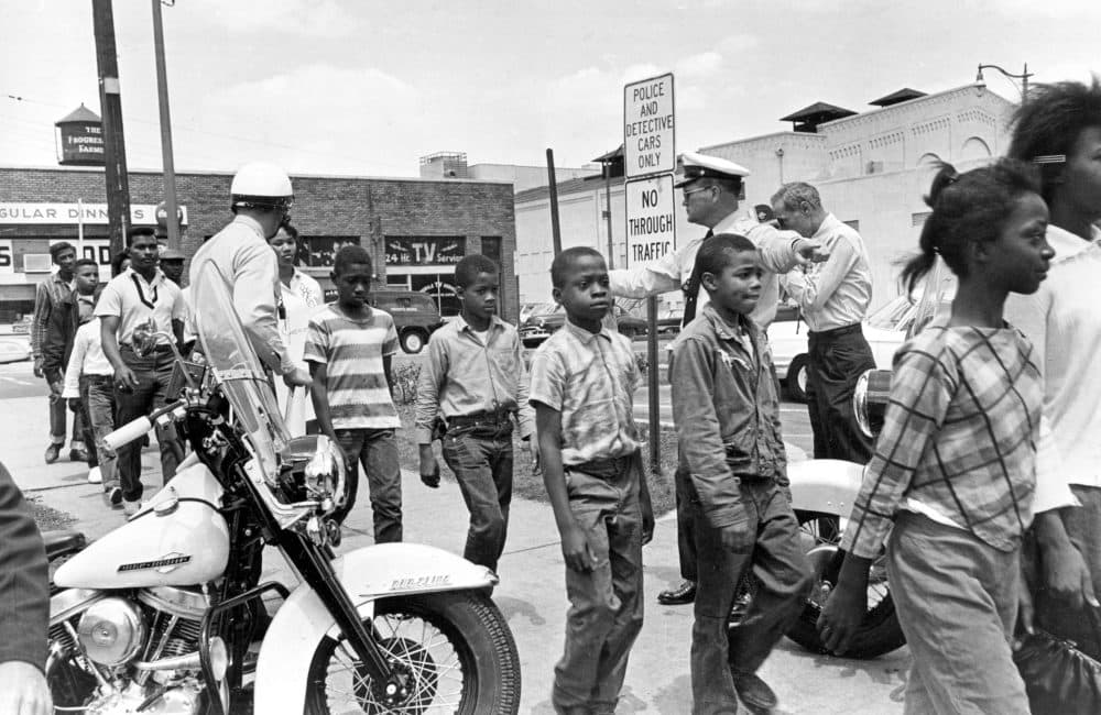 Policemen lead a group of black school children into jail, following their arrest for protesting racial discrimination in Birmingham, Ala., on May 4, 1963. (Bill Hudson/AP)