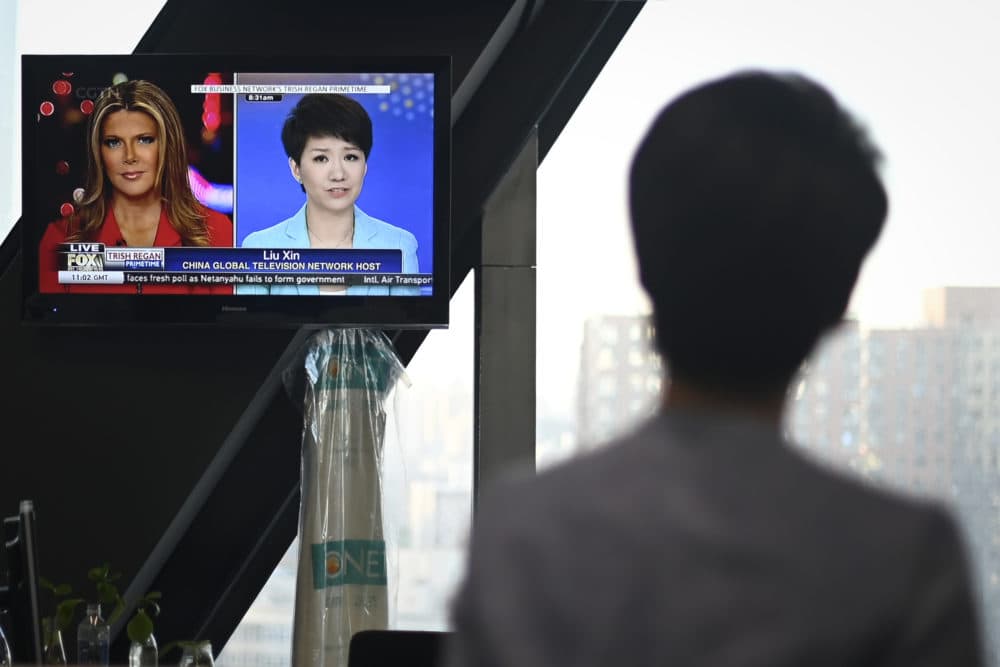 China's state broadcaster CGTN anchor Liu Xin looks at a screen showing her debate with Fox Business Network presenter Trish Regan on May 30, 2019. (Wang Zhao/AFP/Getty Images)