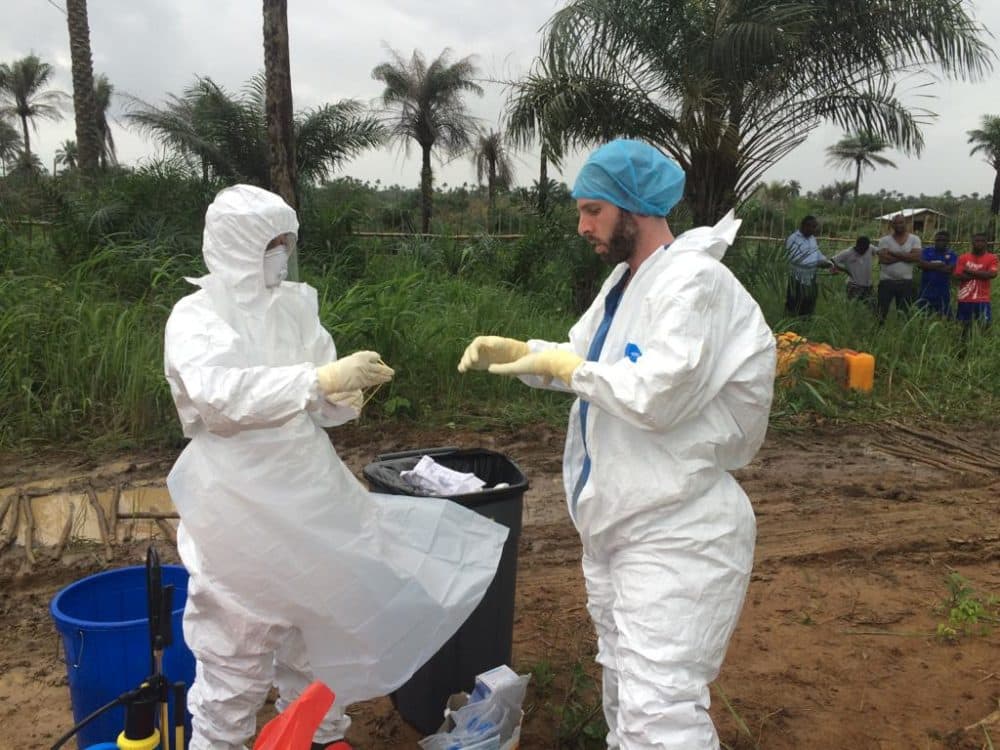 The author (right) puts on protective gear before helping remove waste from Princess Christian Maternity Hospital in Freetown, Sierra Leone, which PIH supported during the Ebola epidemic. (Courtesy Jonathan Lascher)