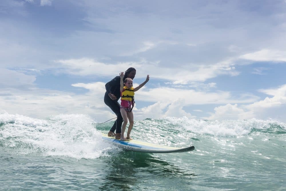 A surfer and a young girl during a Surfers Healing event. (Courtesy of Izzy Paskowitz)