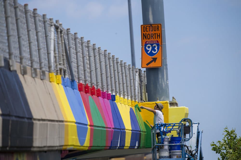 Iker Muro at work, painting the side of I-93. (Jesse Costa/WBUR)