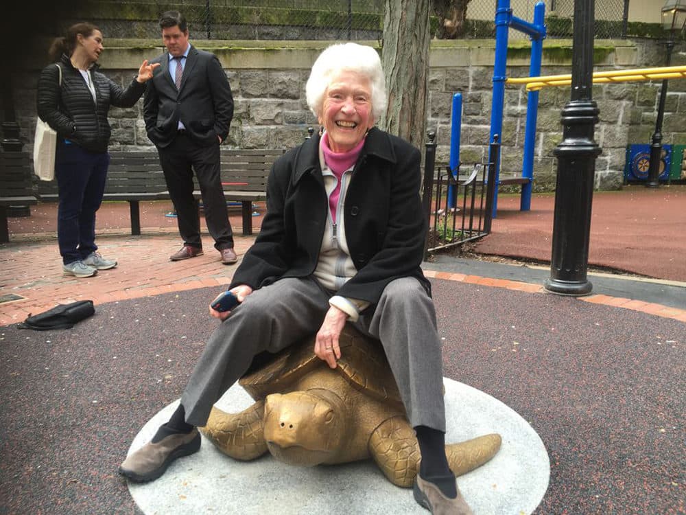 Nancy Schön sits atop her sculpture &quot;Myrtle the Turtle&quot; last month. (Courtesy New England Aquarium)