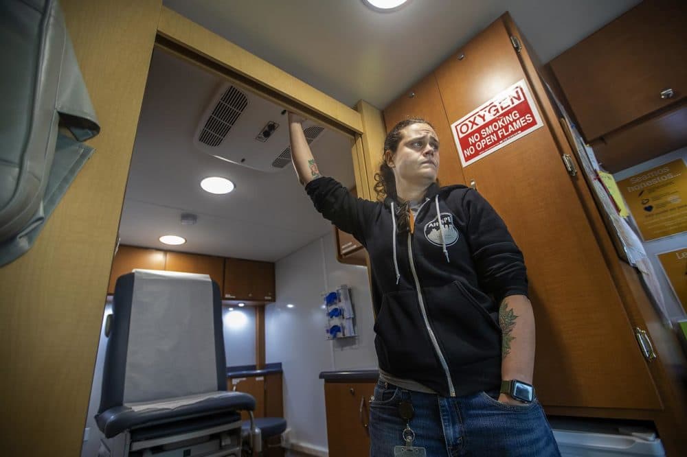 Sarah Mackin holds onto the doorway as the Care Zone van makes its way through downtown Boston. (Jesse Costa/WBUR)