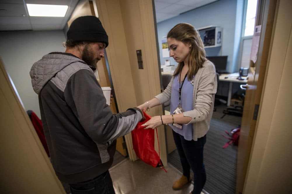 At the Boston Health Care for the Homeless office, case manager Samantha Walsh offers Cody a new backpack for what few belongings he has with him. (Jesse Costa/WBUR)