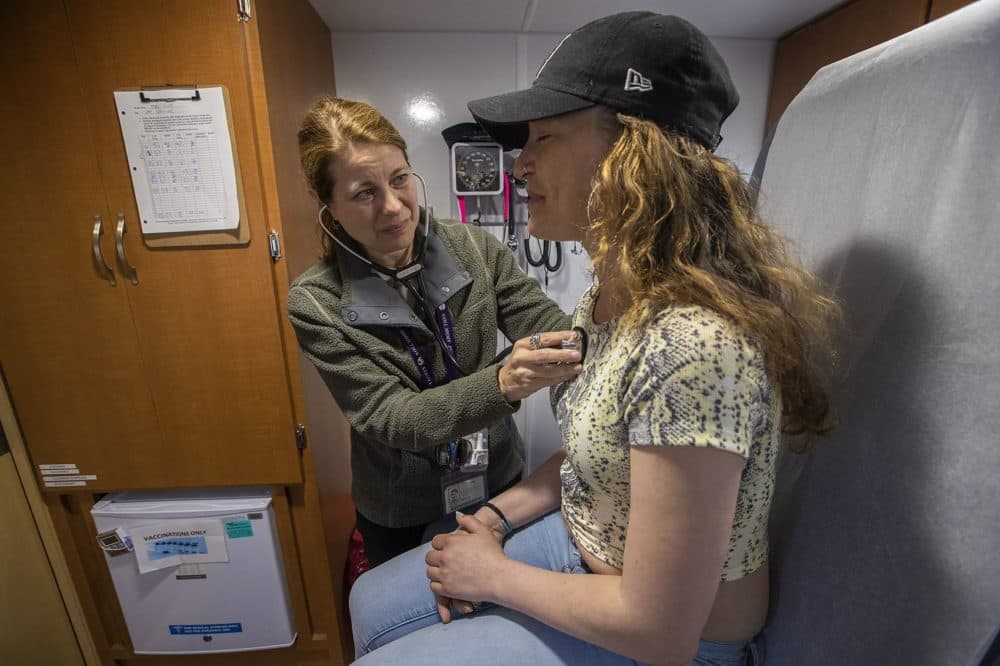 Dr. Jessie Gaeta uses a stethoscope to check Bri's heart rate during a checkup in the mini exam room on the Care Zone van. (Jesse Costa/WBUR)