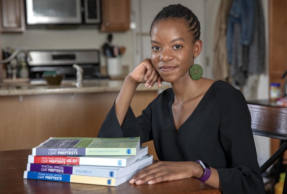 Olivia Castor, seen here with a pile of her LSAT prep test books, will attend Harvard Law School in the fall. (Robin Lubbock/WBUR)