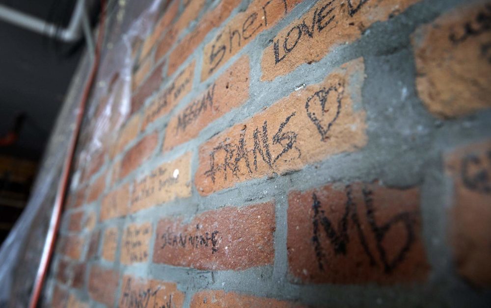 Names written on the brick wall when Fran's Place closed are still preserved today. (Robin Lubbock/WBUR)