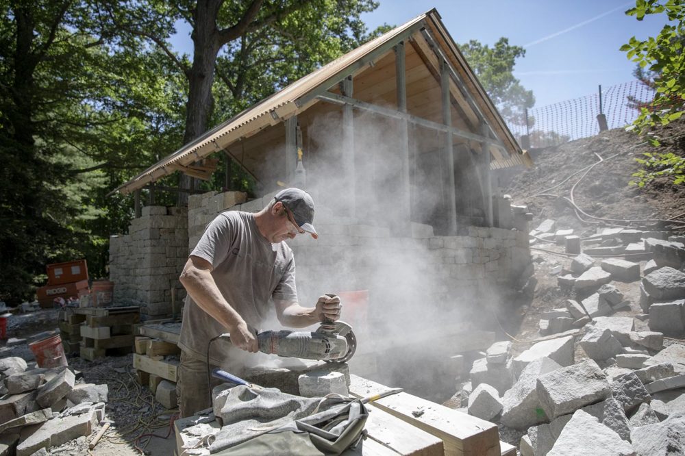 Jason Wilton from Derbyshire, UK, cuts stone during the construction of Watershed. (Robin Lubbock/WBUR)